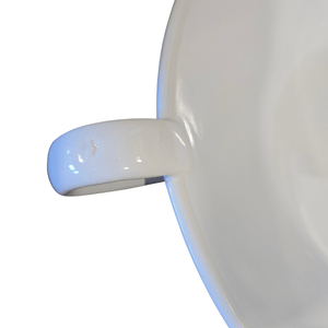 Close-up of a white ceramic bowl with a handle on a white background