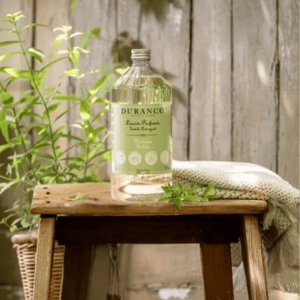 Durance Verbena Detergent bottle in sunlight beside a potted herb – clean, green French laundry care infused with natural vitality.