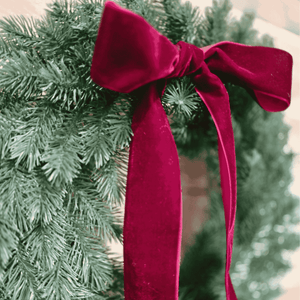Close-up of a red velvet bow on a green wreath