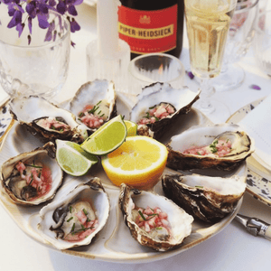 Belon Oyster stand with fresh oysters and champagne - wisteria flower - La Rochere Perigord Champagne Flute