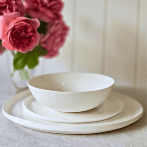 Amitié 12 piece white dinner set on table with roses