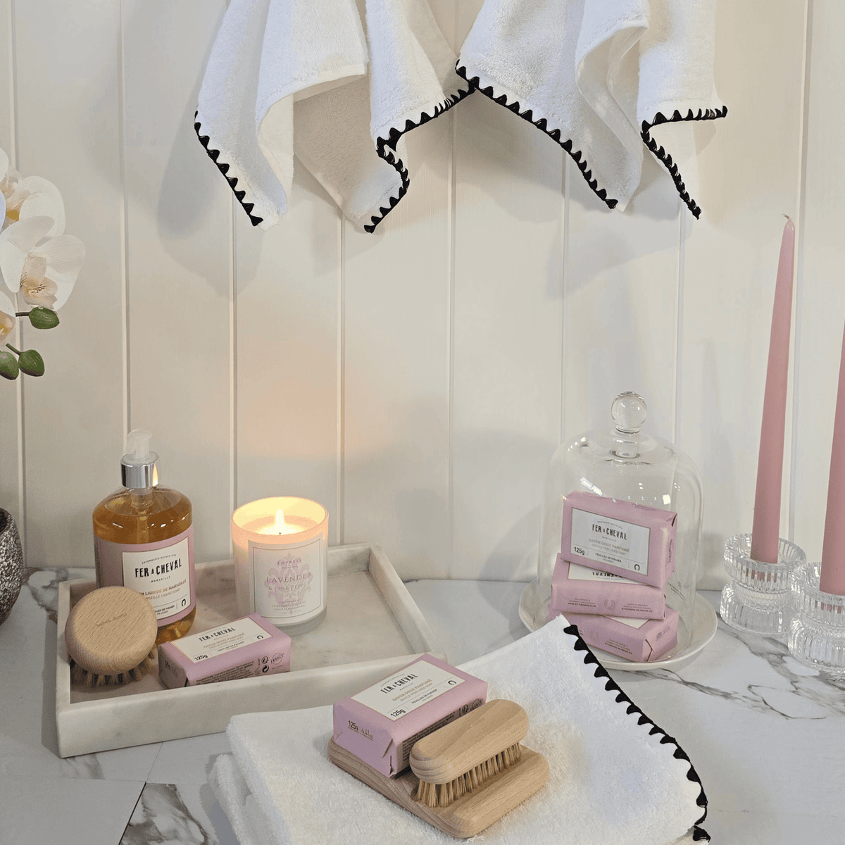 Issey white hand towel styled in a French-inspired bathroom with marble and candle