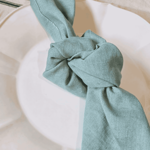 Provence Mint Linen Napkins tied in a knot on a white Vienna Dinner Plate