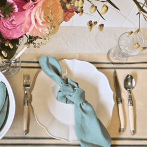 French-inspired table setting with mint linen napkins and white ceramics and flowers