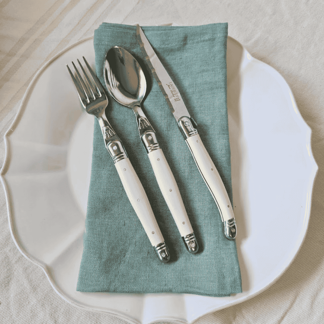 Provence Mint Linen Napkins folded on a white Vienna Dinner Plate with Laguiole cutlery