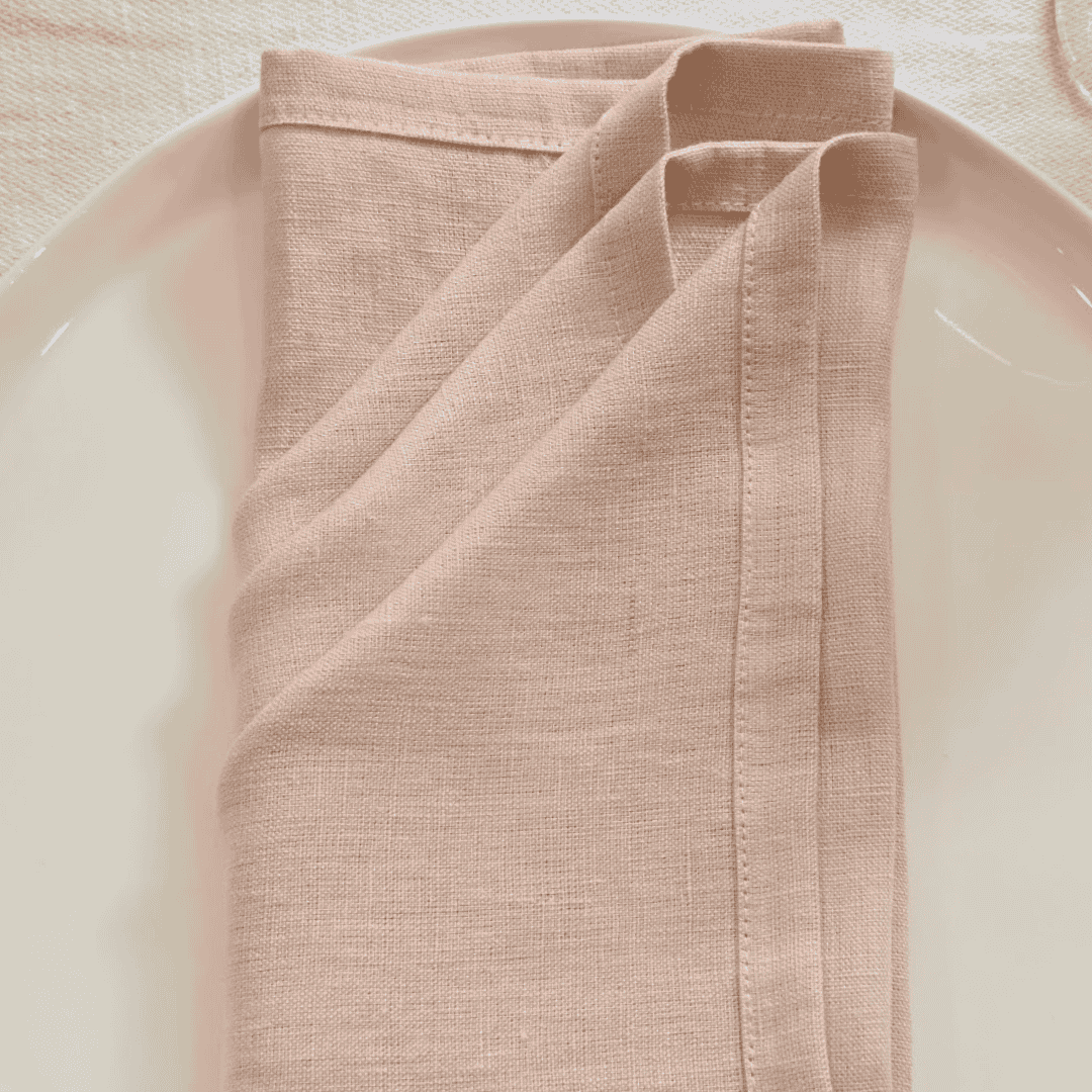 Blush linen napkin styled on white ceramic plate 