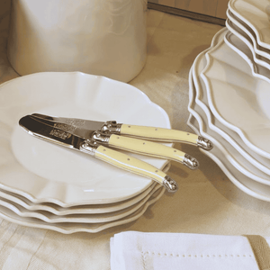 Laguole Ivory Butter knives on a stack of white plates