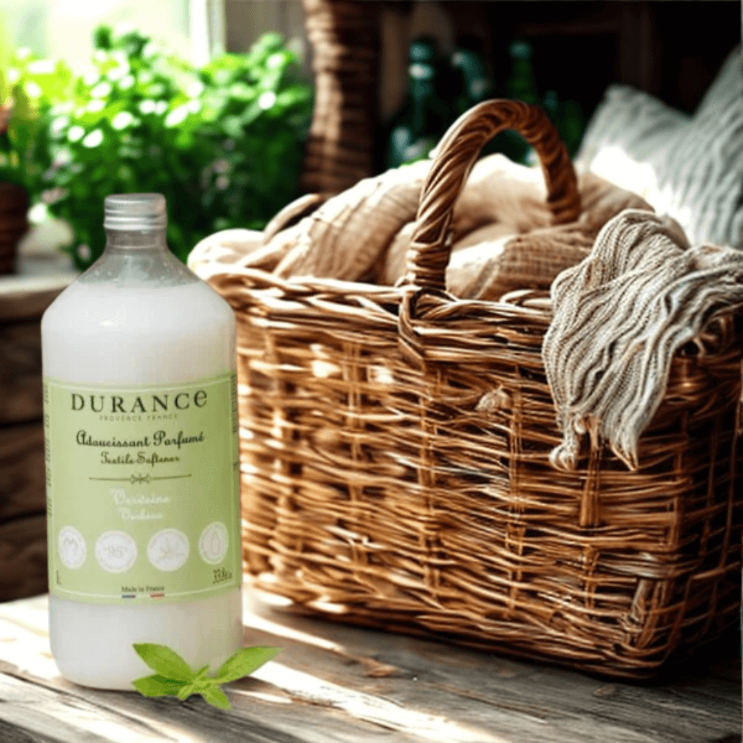 Durance Verbena Fabric Softener bottle beside a woven laundry basket and soft linens – French-made, lemony fresh, and gentle on fabrics.