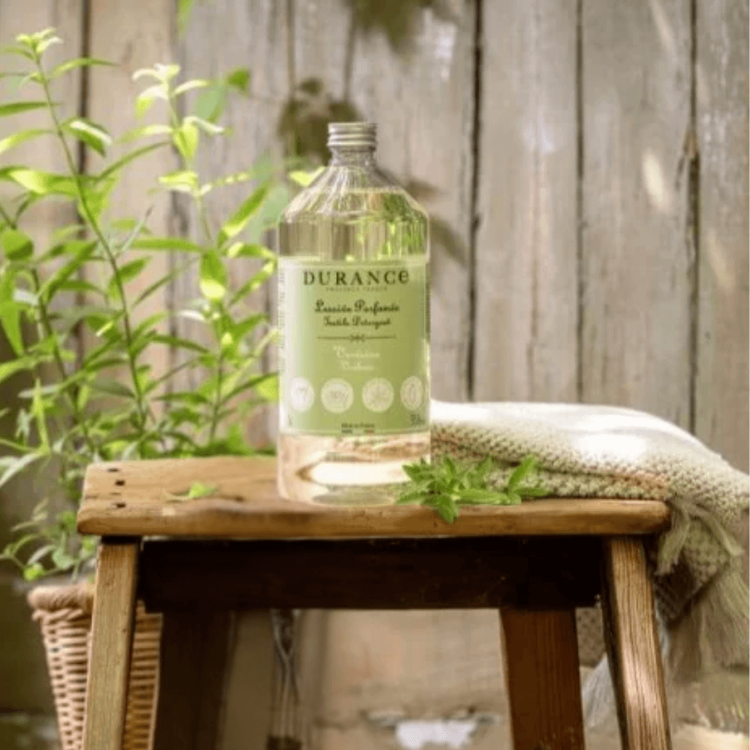 Durance Verbena Detergent bottle in sunlight beside a potted herb – clean, green French laundry care infused with natural vitality.