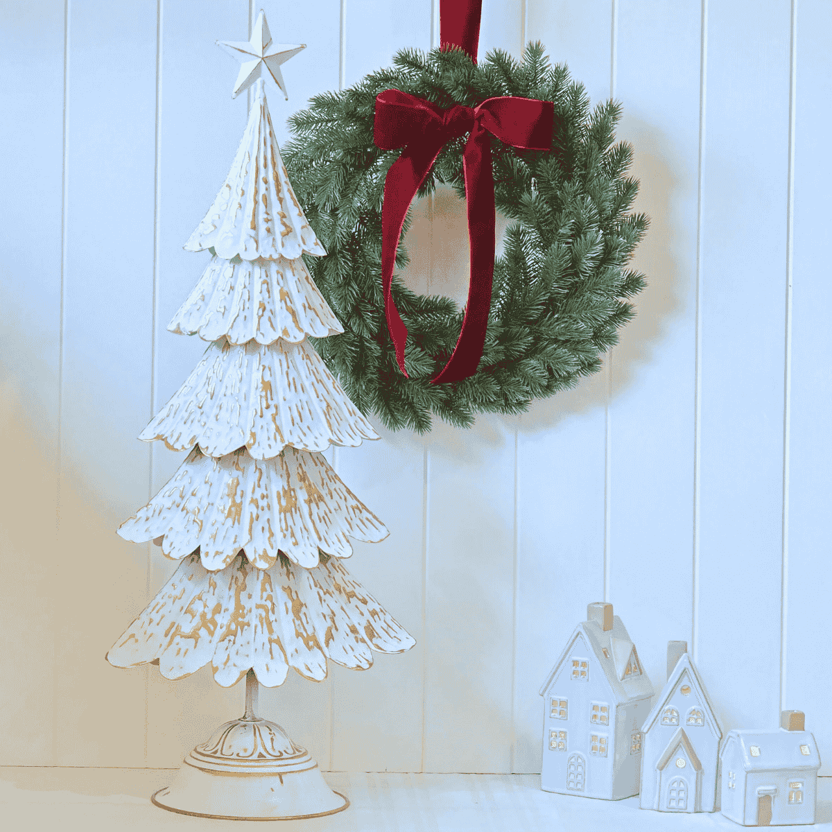 Étoile de Lune Tree in white and gold beside wreath – Malmaison Noël décor