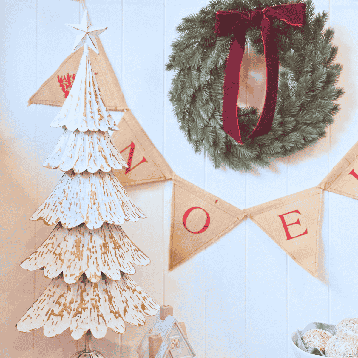 Close-up of embossed gold detailing on tiered metal Christmas tree with Noel Bunting