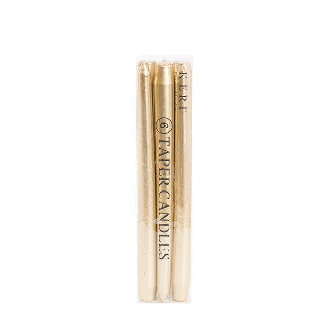 Box of gold taper candles on neutral background