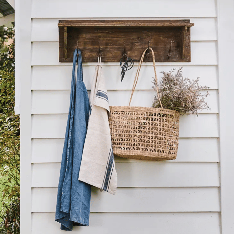 Maison Rustique Hook Shelf with top ledge styled with decor and five hanging hooks.