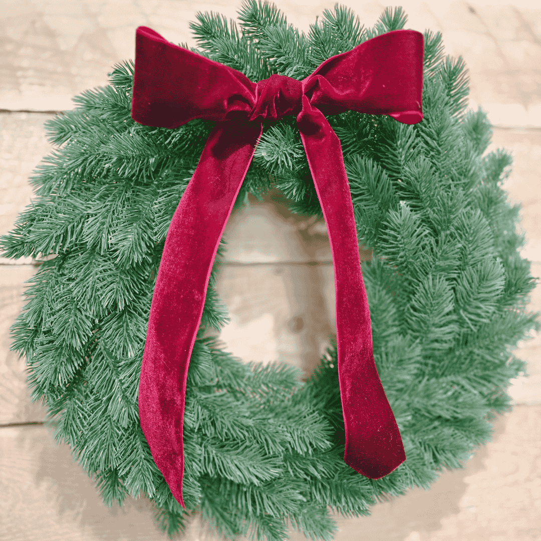 Wreath with velvet bow hung on white panel door – elegant holiday decor