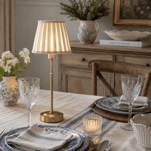 Touch lamp with beige shade and gold base on French Country styled table