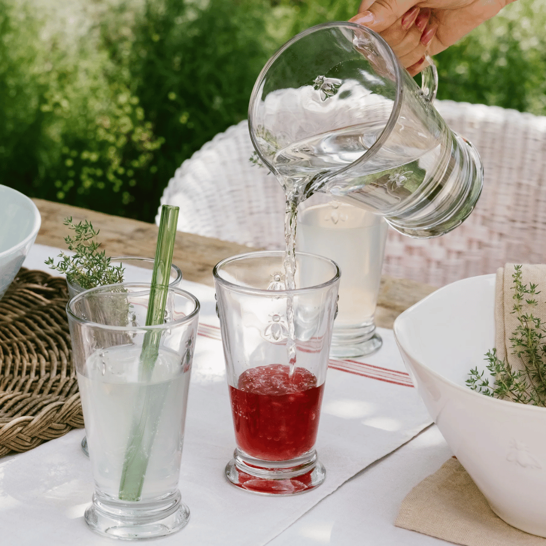 La Rochere Bee Pitcher - Water Jug  pouring into Long Bee water glasses beside Bee Salad Bowl