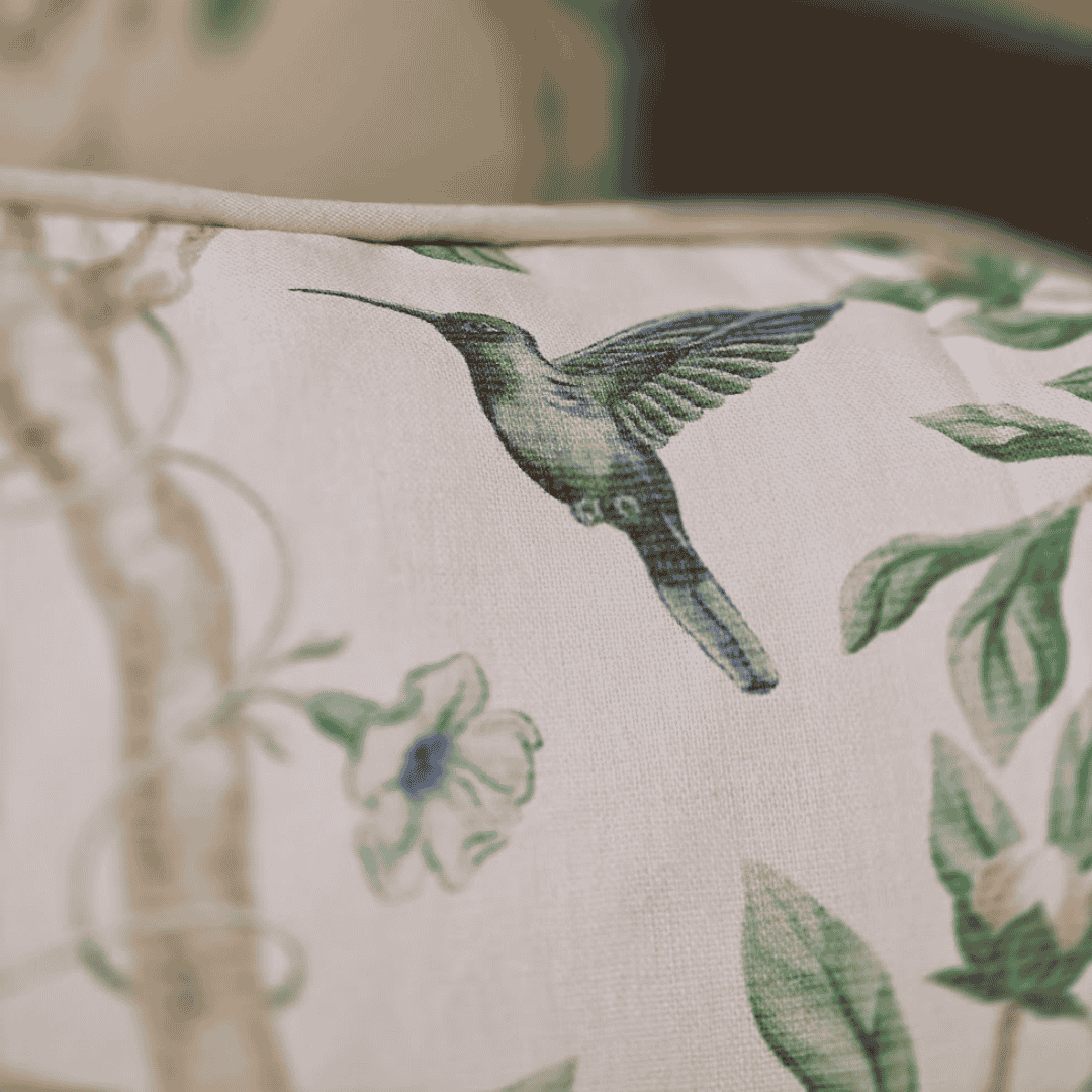 Close-up of a fabric with a green hummingbird design on a beige background