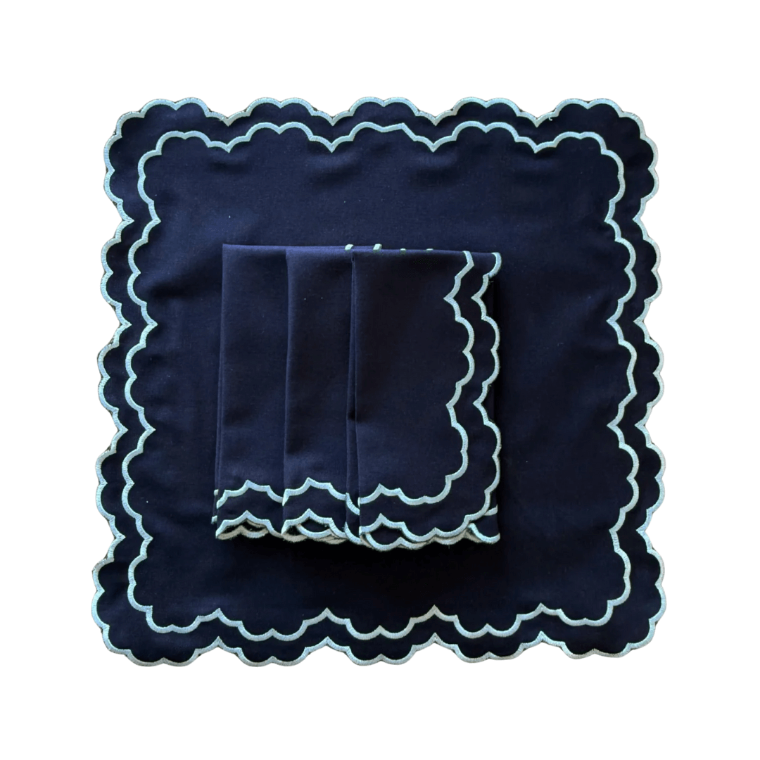 Decorative plate with 'Bon Appetit' text and a blue napkin on a matching tablecloth.  Versailles napkins styled with matching placemats for a coordinated French table