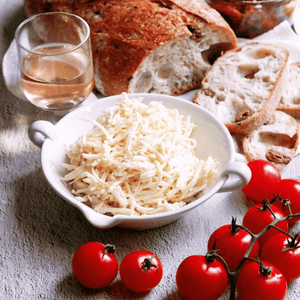 Small White Provence Bowl filled with shredded cheese with bread wine and tomatoes