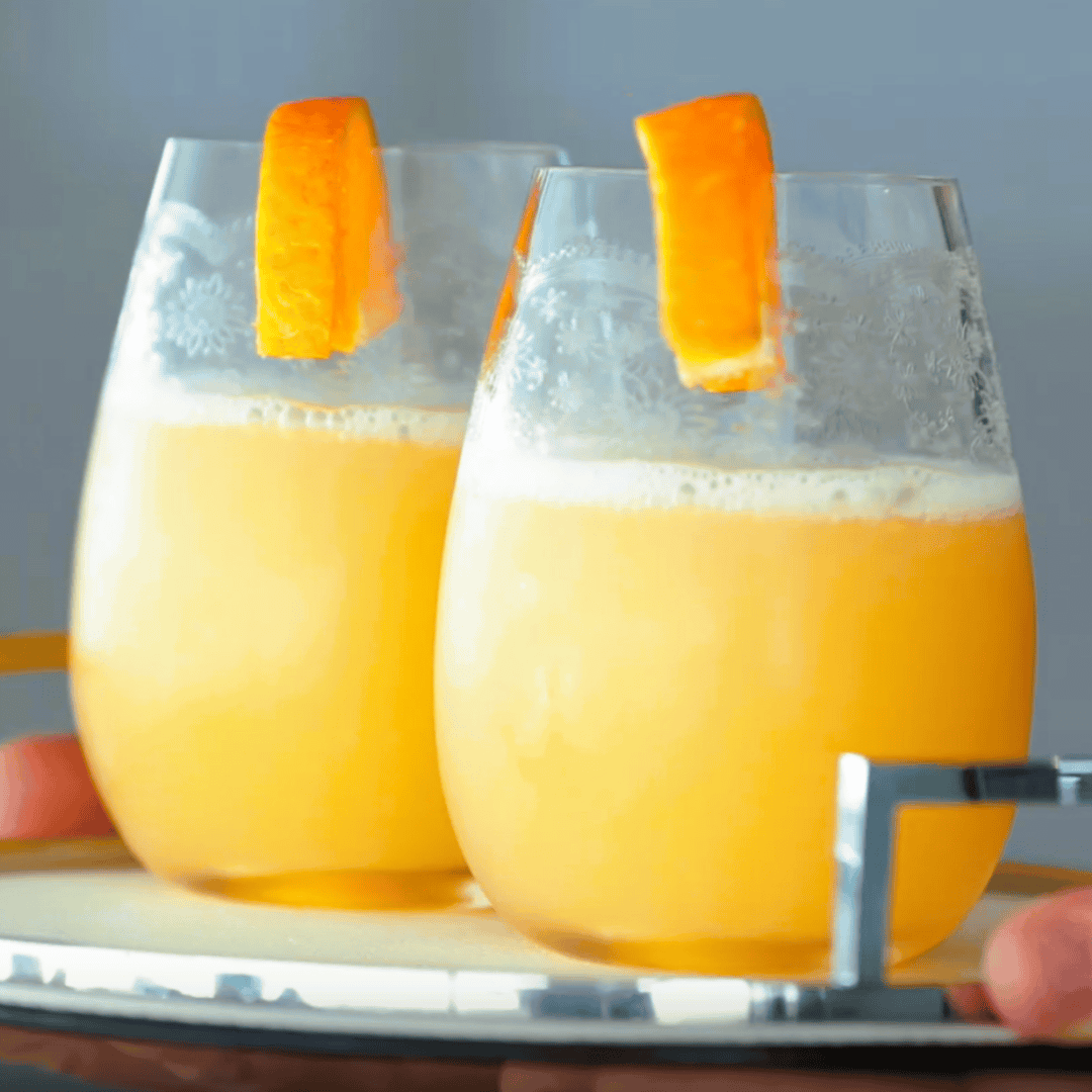 Stemless wine glasses or crystal tumblers filled with orange juice – French style