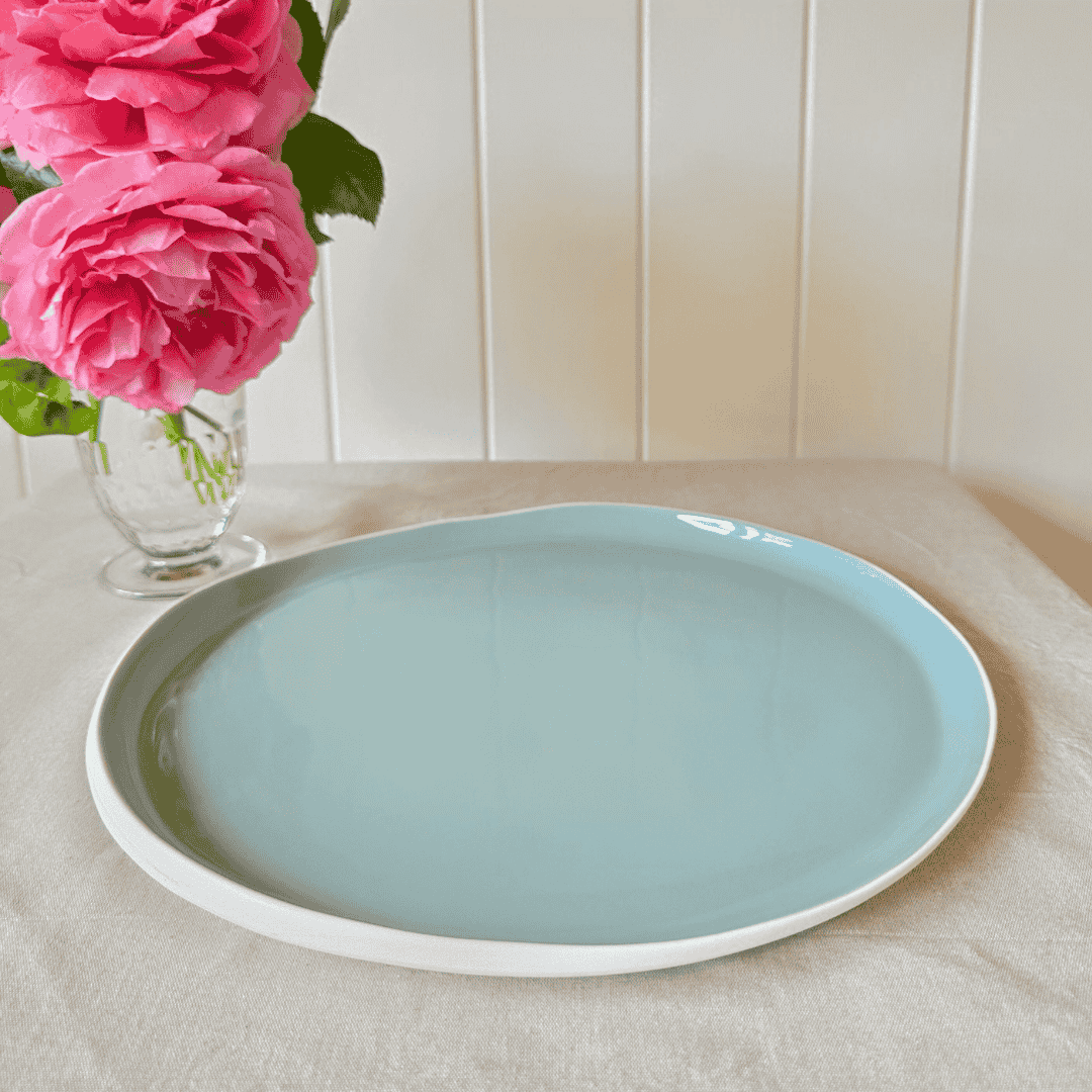 Duck egg blue dinner plate with fresh roses in vase