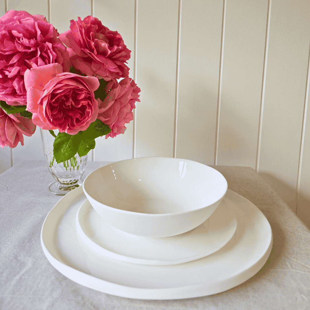 Amitié 12 piece white dinner set on table with roses