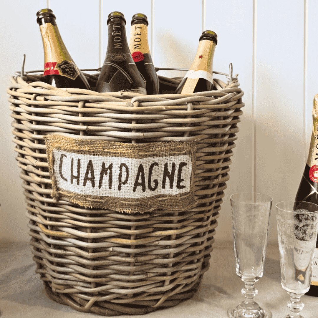 Wicker basket labeled 'Champagne' with Moët & Chandon bottles inside, next to champagne glasses
