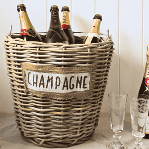Wicker basket labeled 'Champagne' with Moët & Chandon bottles inside, next to champagne glasses