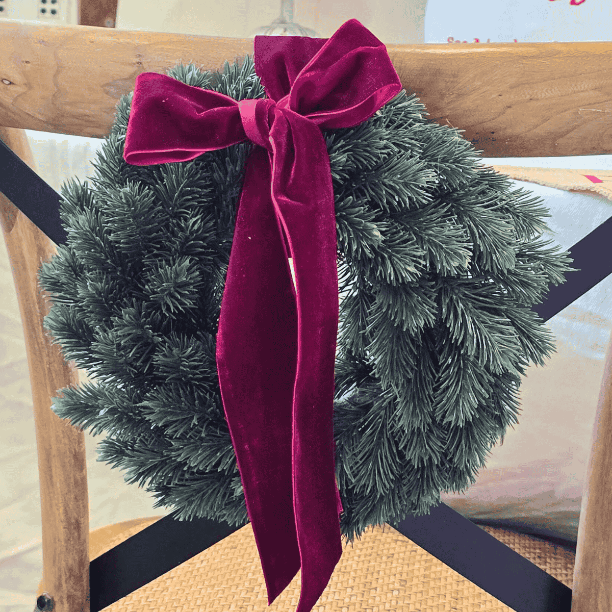 Petite Traditional Christmas Wreath with red velvet bow tied to chair – Malmaison Noël décor