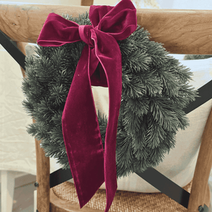 Closeup Traditional Noël Christms Wreath with red velvet bow tied to chair – Malmaison Noël décor