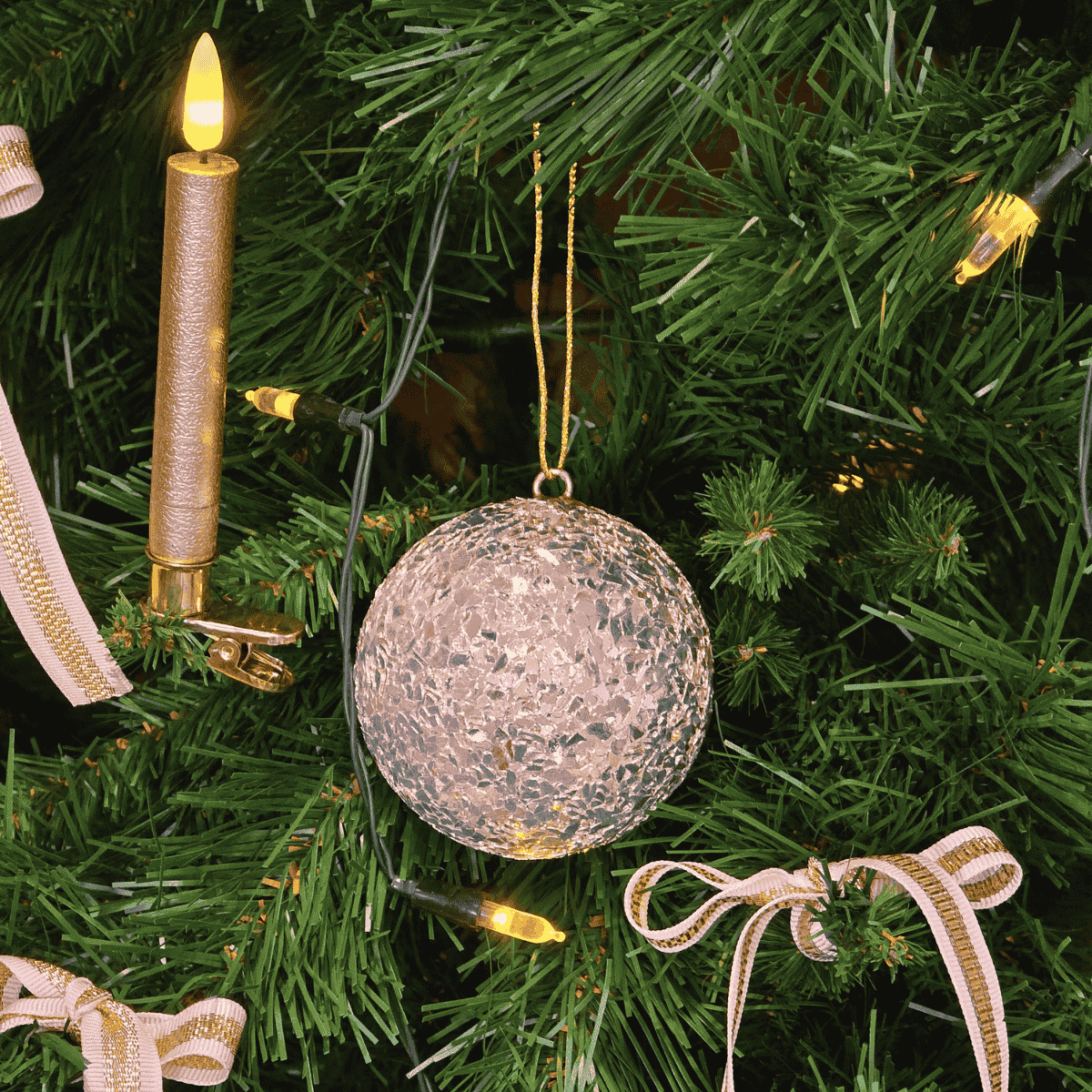 Close-up of champagne textured Christmas bauble reflecting soft lights