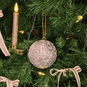 Close-up of champagne textured Christmas bauble reflecting soft lights