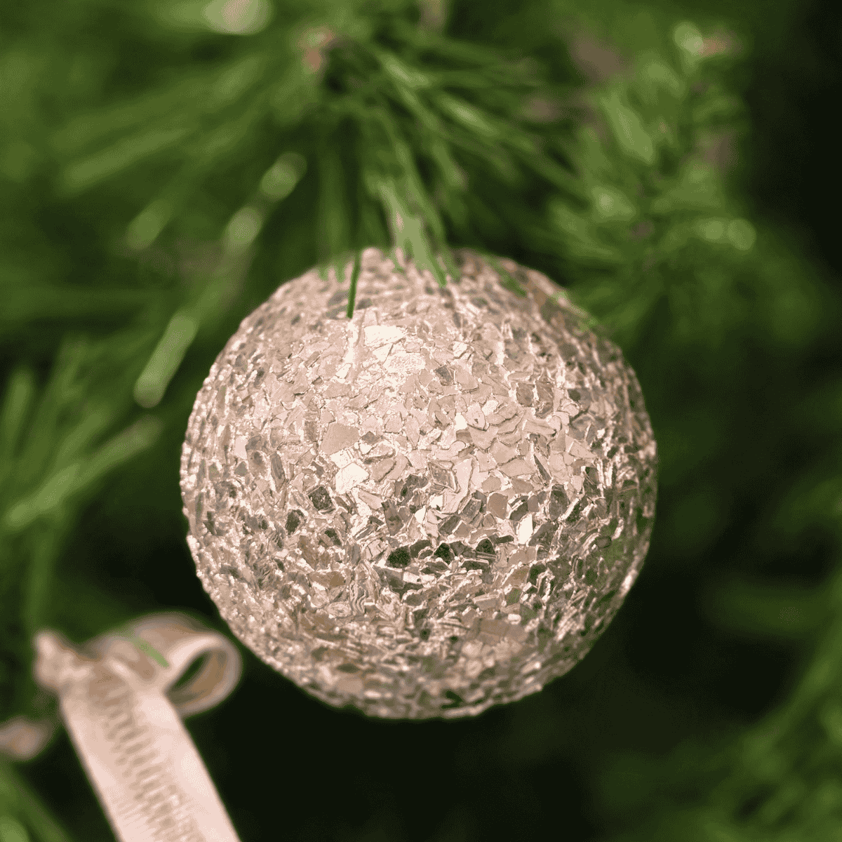 Close-up of champagne textured Christmas bauble reflecting soft lights