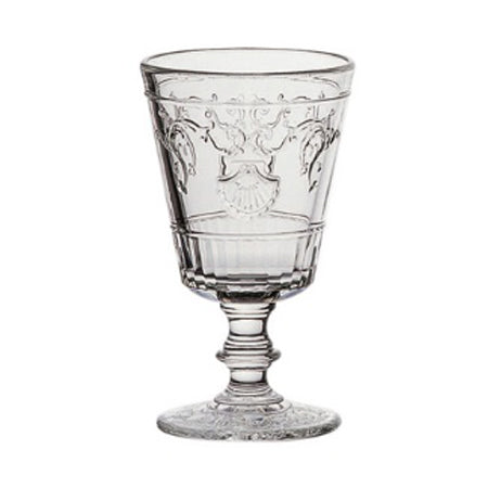 A clear French wine glass with an intricate shell and flower motif design.